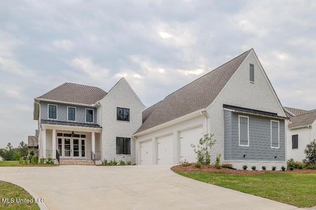 view of front facade with covered porch, a garage, and a front yard