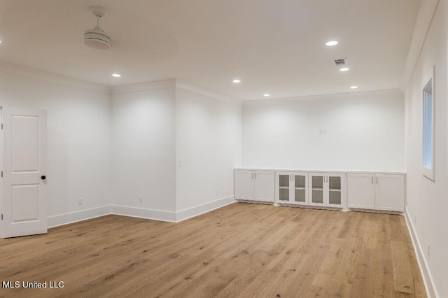 empty room with light hardwood / wood-style floors and ornamental molding