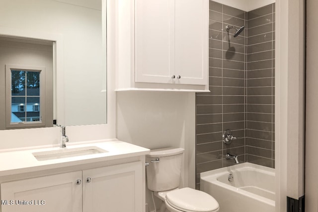 full bathroom featuring tiled shower / bath, vanity, and toilet