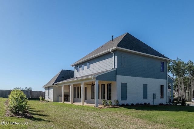 rear view of property featuring a patio and a lawn