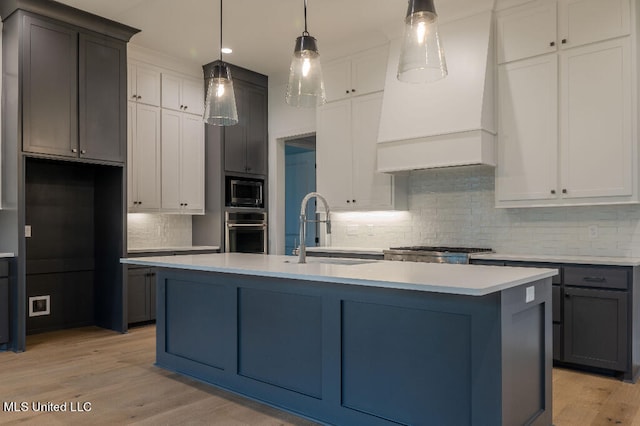 kitchen with a center island with sink, sink, white cabinetry, and stainless steel appliances