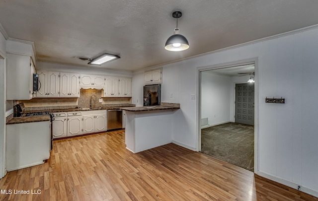 204 Turtle Creek Dr, Brandon, MS 39047 - kitchen with appliances with stainless steel finishes, dark countertops, a peninsula, a sink, and white cabinetry