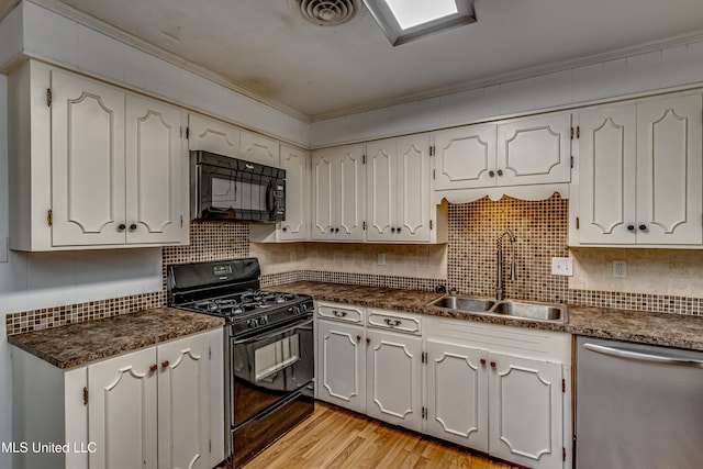 204 Turtle Creek Dr, Brandon, MS 39047 - kitchen featuring black appliances, a sink, dark countertops, decorative backsplash, and white cabinets