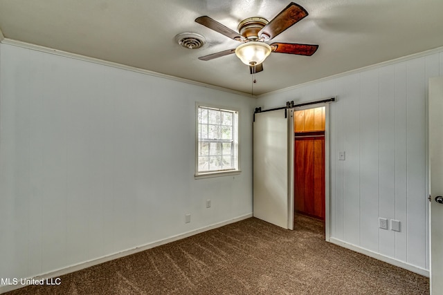 204 Turtle Creek Dr, Brandon, MS 39047 - unfurnished bedroom featuring dark carpet, ornamental molding, a barn door, ceiling fan, and a spacious closet