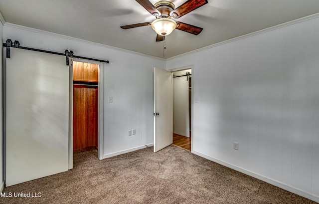 204 Turtle Creek Dr, Brandon, MS 39047 - unfurnished bedroom featuring a barn door, carpet, baseboards, ornamental molding, and a walk in closet