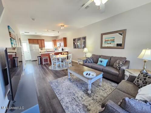 living room with ceiling fan and dark hardwood / wood-style floors