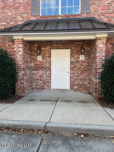 view of exterior entry featuring brick siding