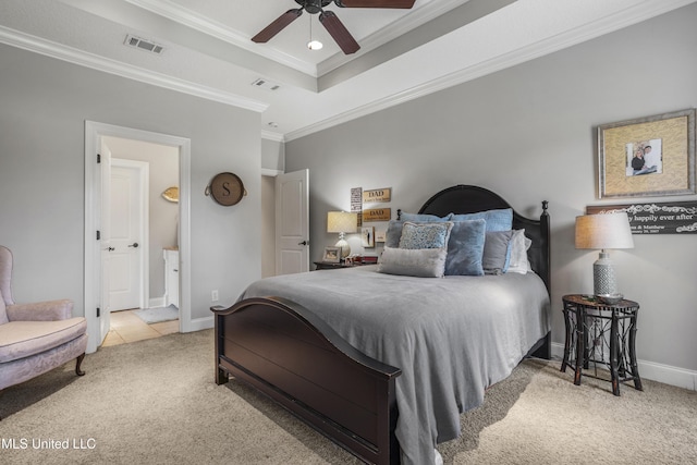 bedroom with crown molding, ensuite bathroom, a tray ceiling, and light carpet