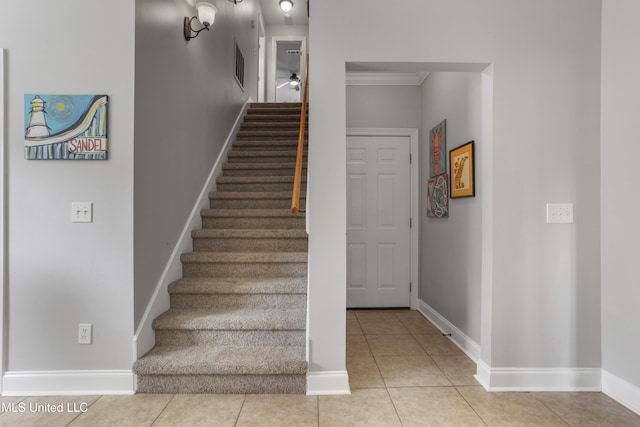 stairs with tile patterned flooring and crown molding