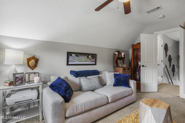 carpeted living room featuring ceiling fan, vaulted ceiling, and a textured ceiling