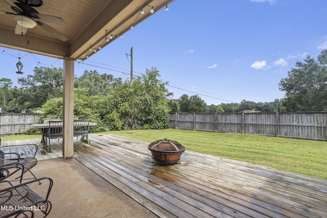 wooden deck with a yard, a fire pit, and ceiling fan