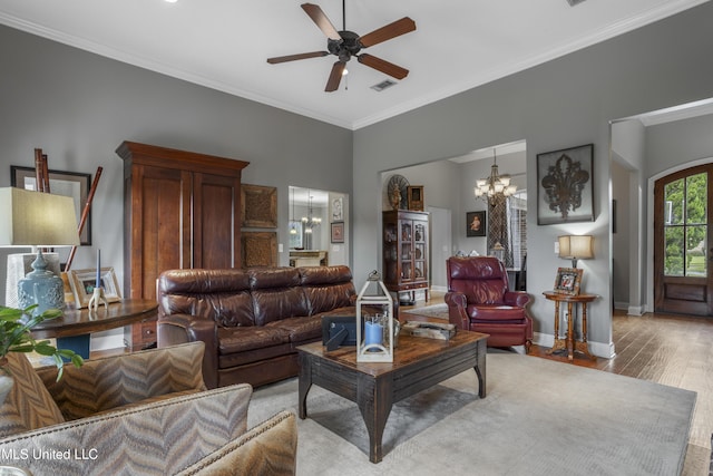 living room with ceiling fan with notable chandelier, light hardwood / wood-style flooring, and ornamental molding