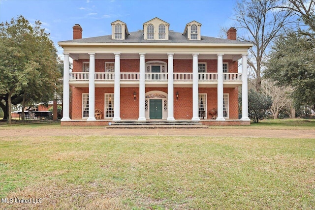 view of front facade with a balcony and a front lawn