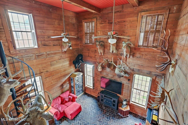 living room with beam ceiling and wooden walls