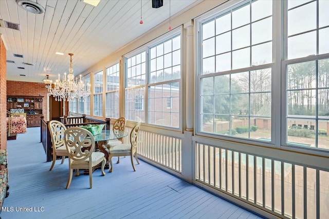 sunroom / solarium with wooden ceiling and an inviting chandelier