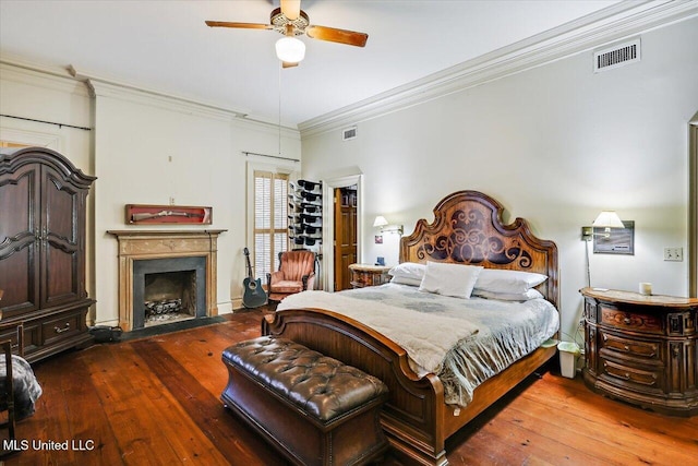 bedroom featuring ceiling fan, ornamental molding, and dark wood-type flooring