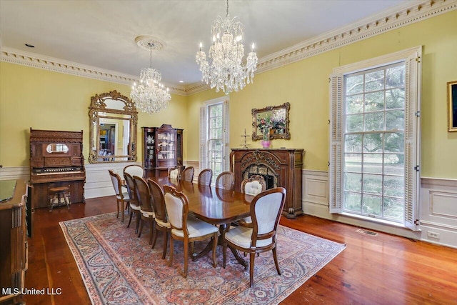 dining room featuring dark hardwood / wood-style floors, ornamental molding, and a notable chandelier