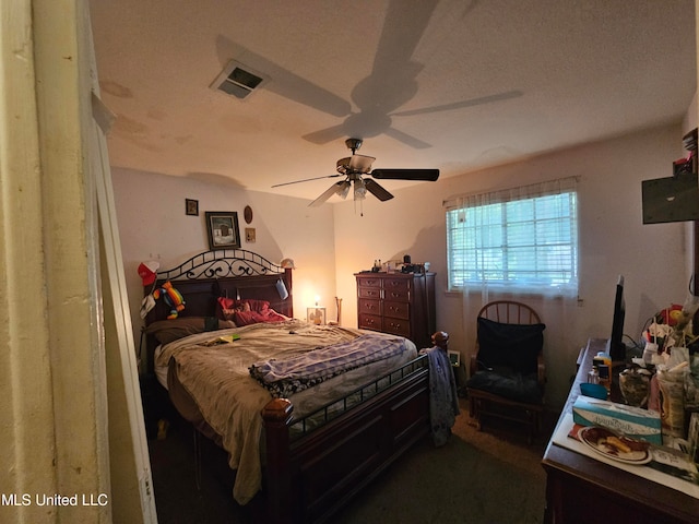 bedroom with ceiling fan and a textured ceiling