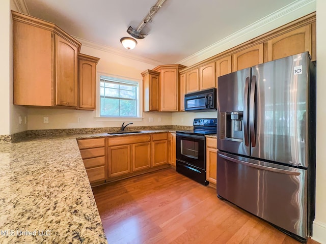 796 Hapuna Pl, Diamondhead, MS 39525 - kitchen featuring black appliances, a sink, crown molding, light wood-style floors, and brown cabinets