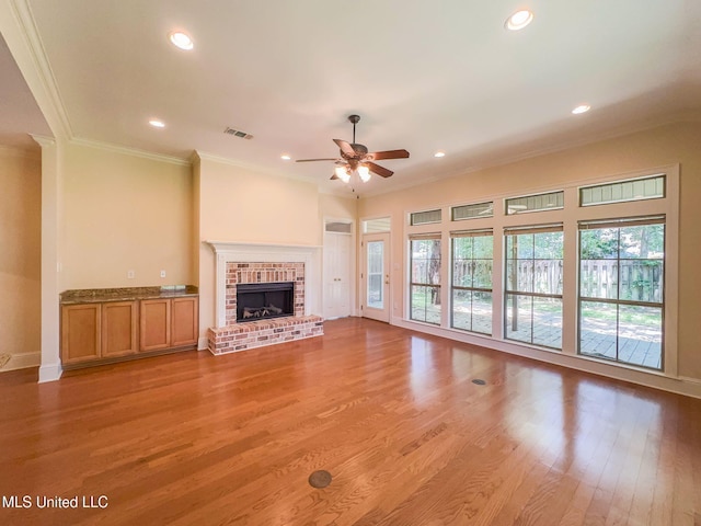 796 Hapuna Pl, Diamondhead, MS 39525 - unfurnished living room with a ceiling fan, crown molding, light wood-style flooring, recessed lighting, and a fireplace