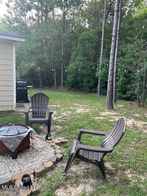 15501 Quail Creek Cv, Diberville, MS 39540 - view of yard with an outdoor fire pit and a wooded view