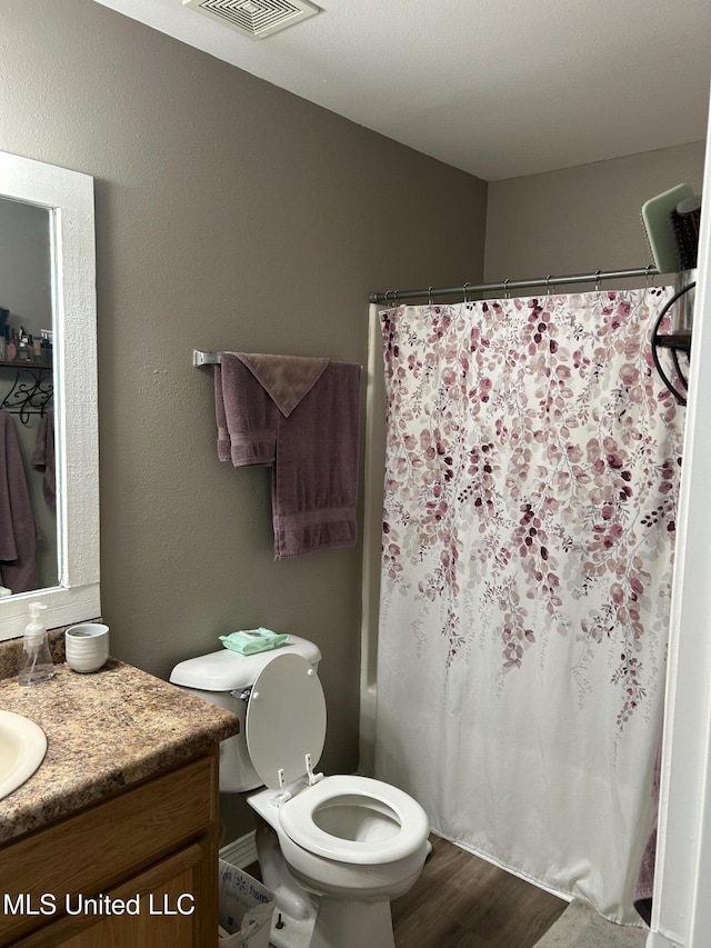 15501 Quail Creek Cv, Diberville, MS 39540 - bathroom featuring vanity, toilet, wood finished floors, and a shower with curtain