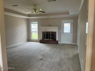 unfurnished living room featuring crown molding, carpet floors, ceiling fan, and a wealth of natural light