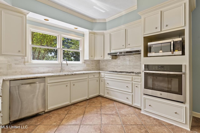 1034 Northpointe Dr, Jackson, MS 39211 - kitchen with appliances with stainless steel finishes, under cabinet range hood, a sink, crown molding, and tasteful backsplash
