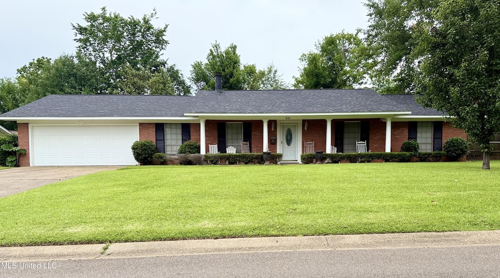 ranch-style home featuring brick siding, a garage, a porch, concrete driveway, and a front lawn