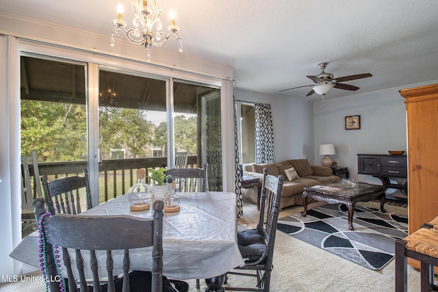 dining space featuring carpet floors, a textured ceiling, and ceiling fan with notable chandelier