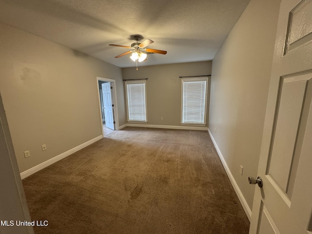 carpeted spare room featuring ceiling fan and a textured ceiling