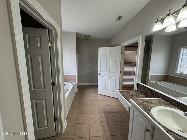 bathroom with vanity, a tub to relax in, and tile patterned flooring