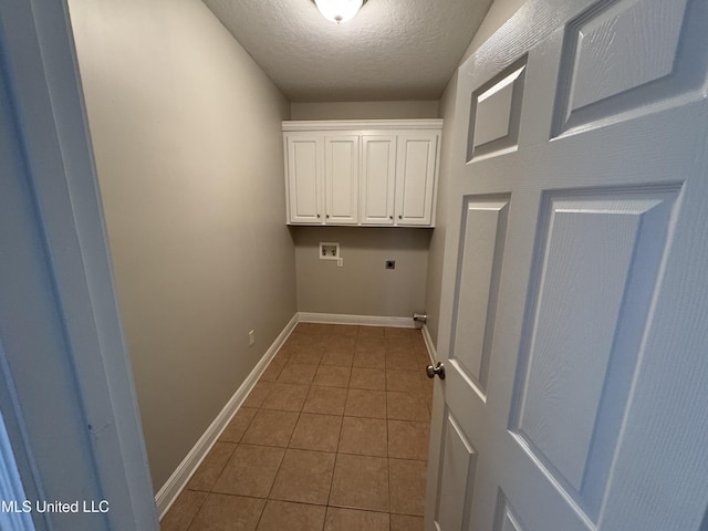 clothes washing area with tile patterned floors, cabinets, a textured ceiling, washer hookup, and hookup for an electric dryer