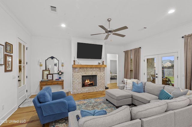 970 Glenwild Cir, Canton, MS 39046 - living room with light wood-type flooring, ornamental molding, french doors, ceiling fan, and a fireplace