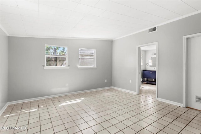 spare room with ornamental molding and light tile patterned floors