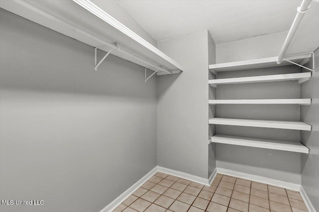 spacious closet with light tile patterned floors