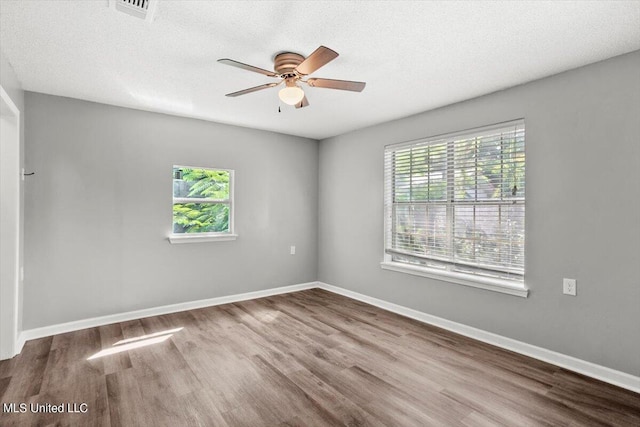 spare room featuring ceiling fan, hardwood / wood-style floors, and a textured ceiling