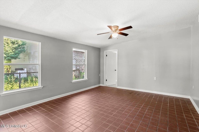 tiled empty room with a textured ceiling and ceiling fan