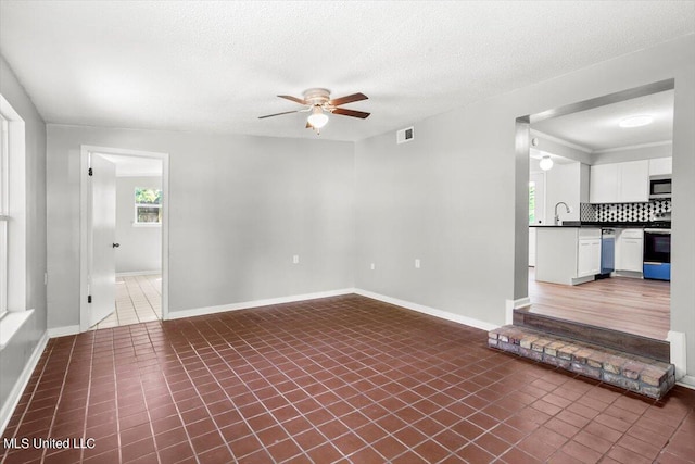 spare room featuring tile patterned flooring, sink, a textured ceiling, and ceiling fan