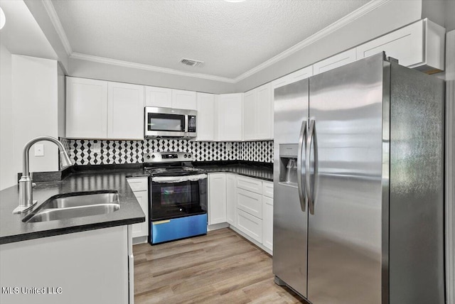 kitchen featuring sink, ornamental molding, white cabinets, and appliances with stainless steel finishes