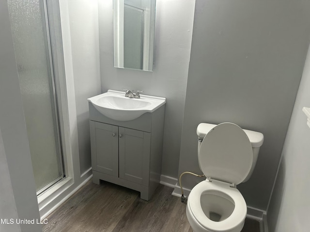 558 Daniel Cir, Jackson, MS 39212 - bathroom with wood finished floors, vanity, toilet, a shower stall, and baseboards