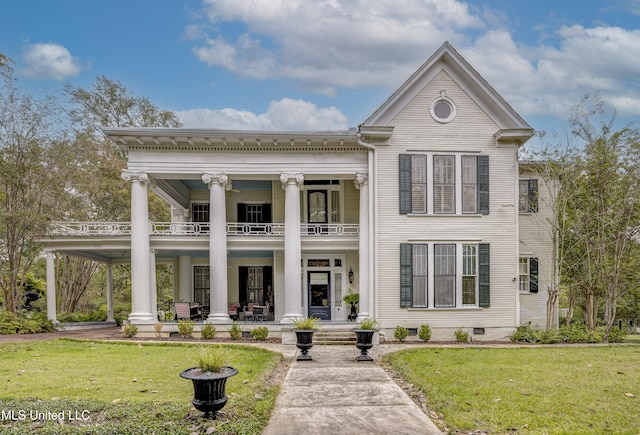 greek revival house featuring a balcony, a front lawn, and a porch