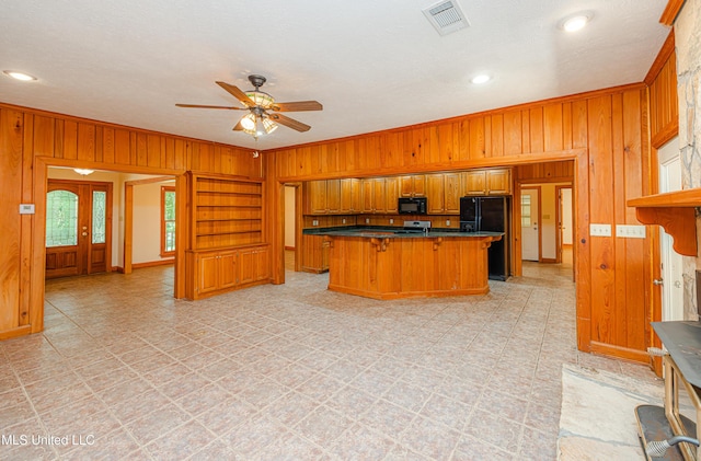 4005 Warriors Trl, Vicksburg, MS 39180 - kitchen with black appliances, wooden walls, brown cabinetry, a ceiling fan, and crown molding