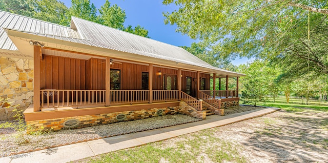 4005 Warriors Trl, Vicksburg, MS 39180 - view of front of house with covered porch, a ceiling fan, metal roof, stone siding, and board and batten siding
