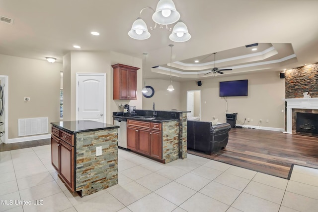 kitchen with light hardwood / wood-style flooring, dishwasher, ceiling fan with notable chandelier, pendant lighting, and a center island