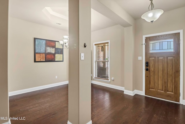 foyer with dark wood-type flooring and a chandelier