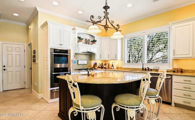 kitchen featuring hanging light fixtures, stainless steel appliances, a center island, and light stone countertops