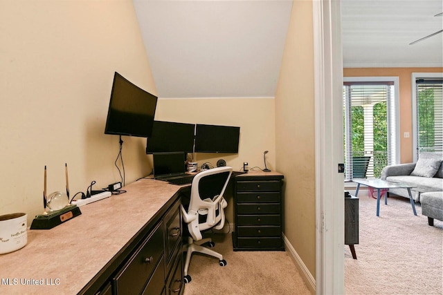 carpeted home office with built in desk, vaulted ceiling, and ornamental molding