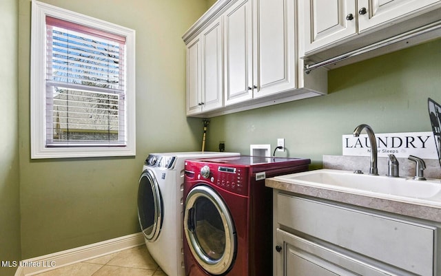 laundry area featuring sink, light tile patterned floors, washing machine and dryer, and cabinets