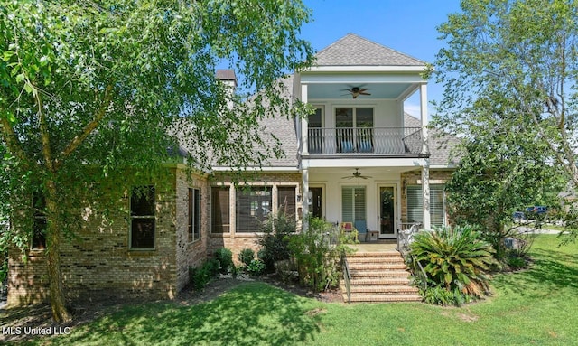 view of front of home featuring ceiling fan, covered porch, a balcony, and a front yard